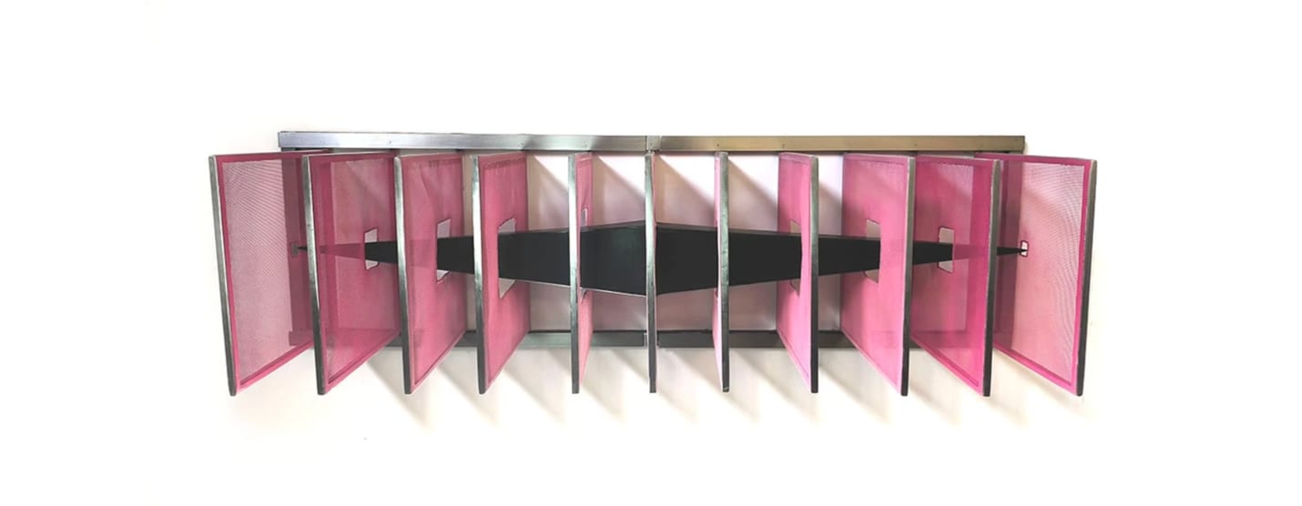 Escultura mural abstracta de Vanesa Muñoz: una hilera de paneles translúcidos de malla rosa enmarcados en acero, con una banda negra que atraviesa horizontalmente el centro